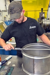 Metal Spinning - Image of Church Metal employee measuring spun part